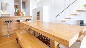 A modern kitchen with a long wooden countertop, bar stools, and a built-in oven. - Stunning 5-room duplex, 10 people, panoramic view, direct ski access, Avoriaz (Avoriaz)
