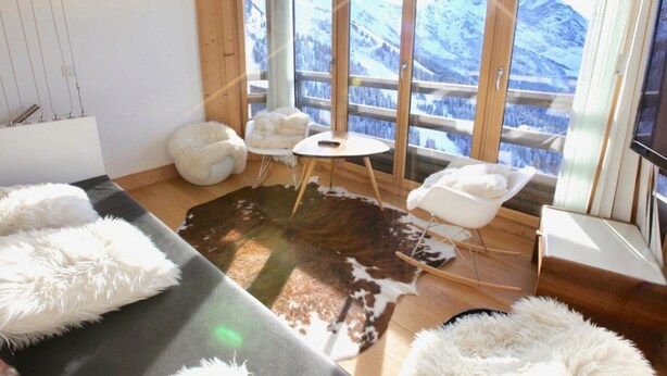 A modern room with a large window, a cozy seating area, and a flat-screen TV. - Stunning 5-room duplex, 10 people, panoramic view, direct ski access, Avoriaz (Avoriaz)