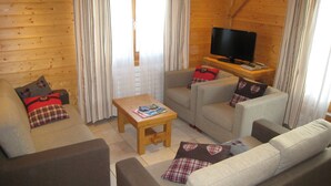 A cozy living room with a sofa set, a coffee table, and a flat-screen TV. - 3 bedrooms, private parking, Wi-Fi, Les Gets (Les Gets)