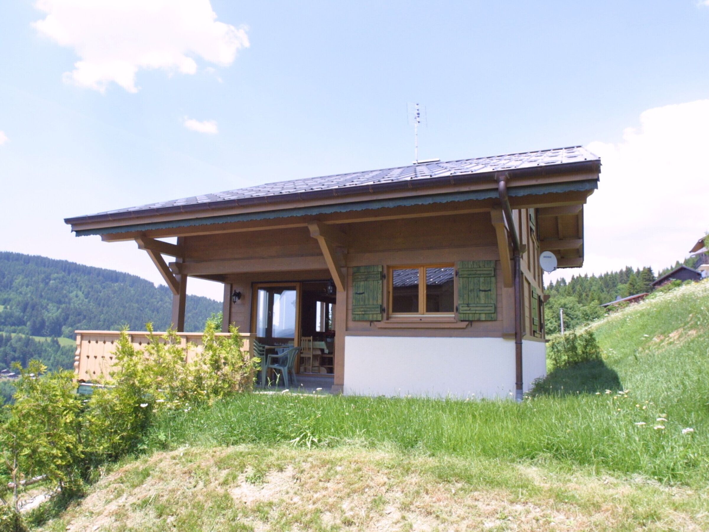 A chalet-style building with a sloped roof, wooden exterior, and a balcony.