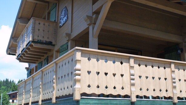 Un edificio in legno con un balcone e una campana.