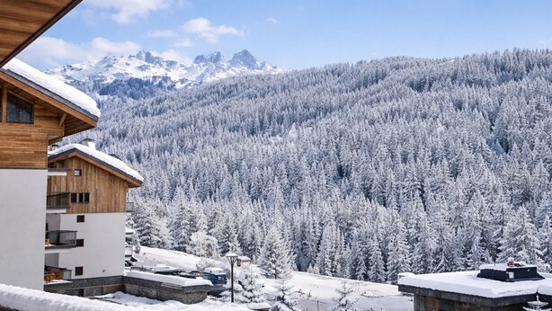 A wooden building with a snow-covered roof, overlooking a forested mountain range. - New Ski-In/Ski-Out, 3 Bedrooms with WiFi and Parking (Courchevel 1650)