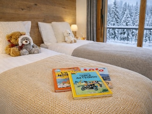 A cozy hotel room with a bed, two pillows, a teddy bear, and a window with a snowy view. - New Ski-In/Ski-Out, 3 Bedrooms with WiFi and Parking (Courchevel 1650)