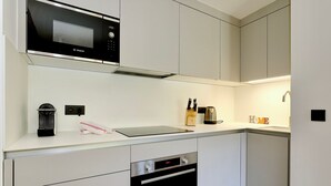 A modern kitchen with a Bosch microwave, a coffee machine, and a kettle on the counter. - New Ski-In/Ski-Out, 3 Bedrooms with WiFi and Parking (Courchevel 1650)