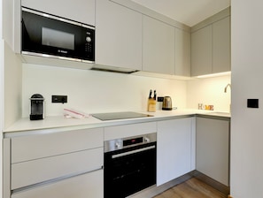 A modern kitchen with a Bosch microwave, a coffee machine, and a kettle on the counter. - New Ski-In/Ski-Out, 3 Bedrooms with WiFi and Parking (Courchevel 1650)