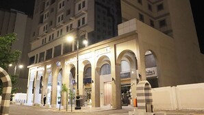 A hotel with multiple floors, arched entrances, and a parking sign.