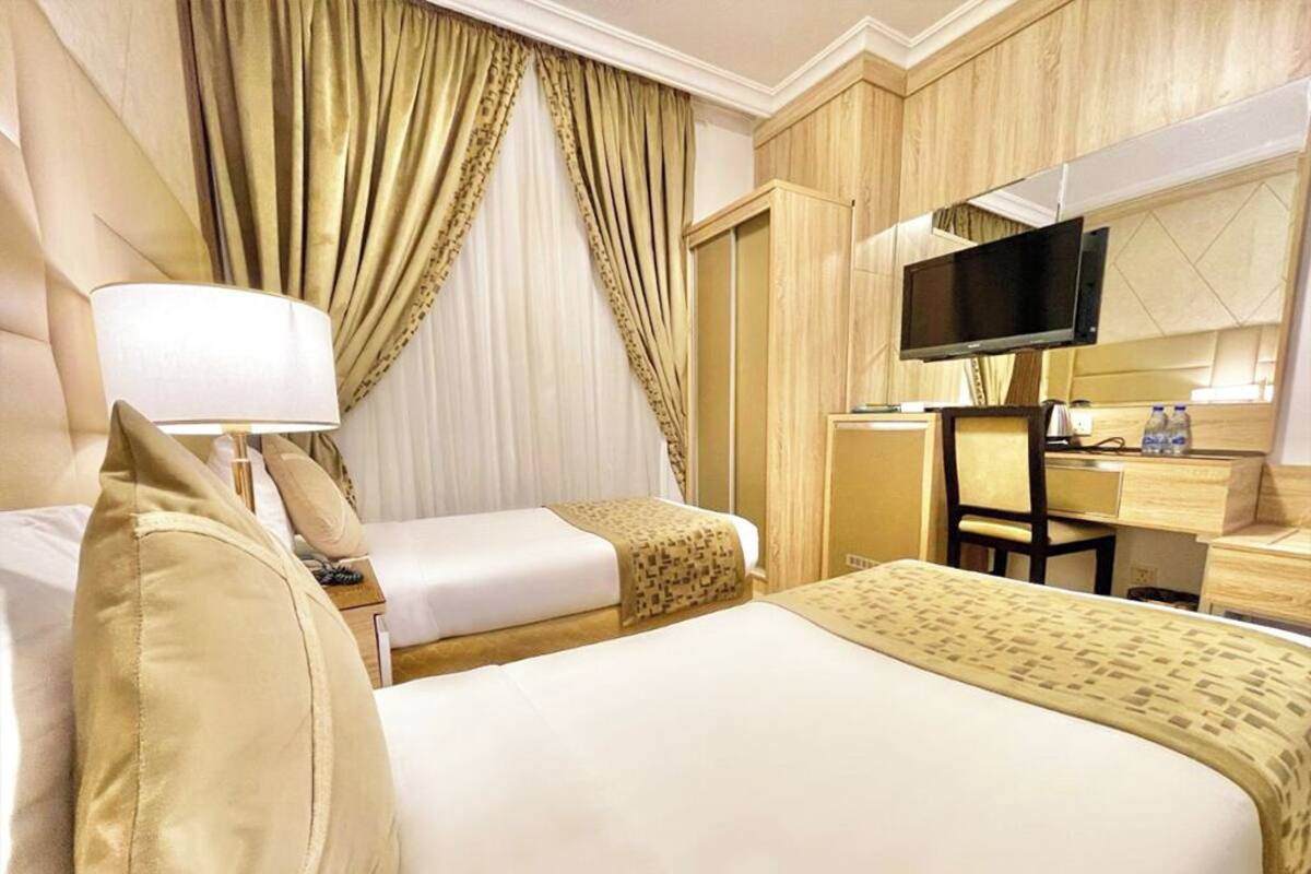 Une chambre d’h ôtel avec deux lits, une télévision, un bureau et une armoire.