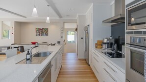 A modern kitchen with a central island, stainless steel appliances, and pendant lighting.