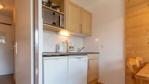 A compact kitchen with a microwave, coffee maker, and dishwasher. - Charming studio for 4 in Avoriaz with balcony (Avoriaz)