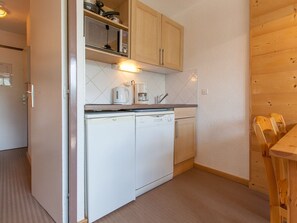 A compact kitchen with a microwave, coffee maker, and dishwasher. - Charming studio for 4 in Avoriaz with balcony (Avoriaz)