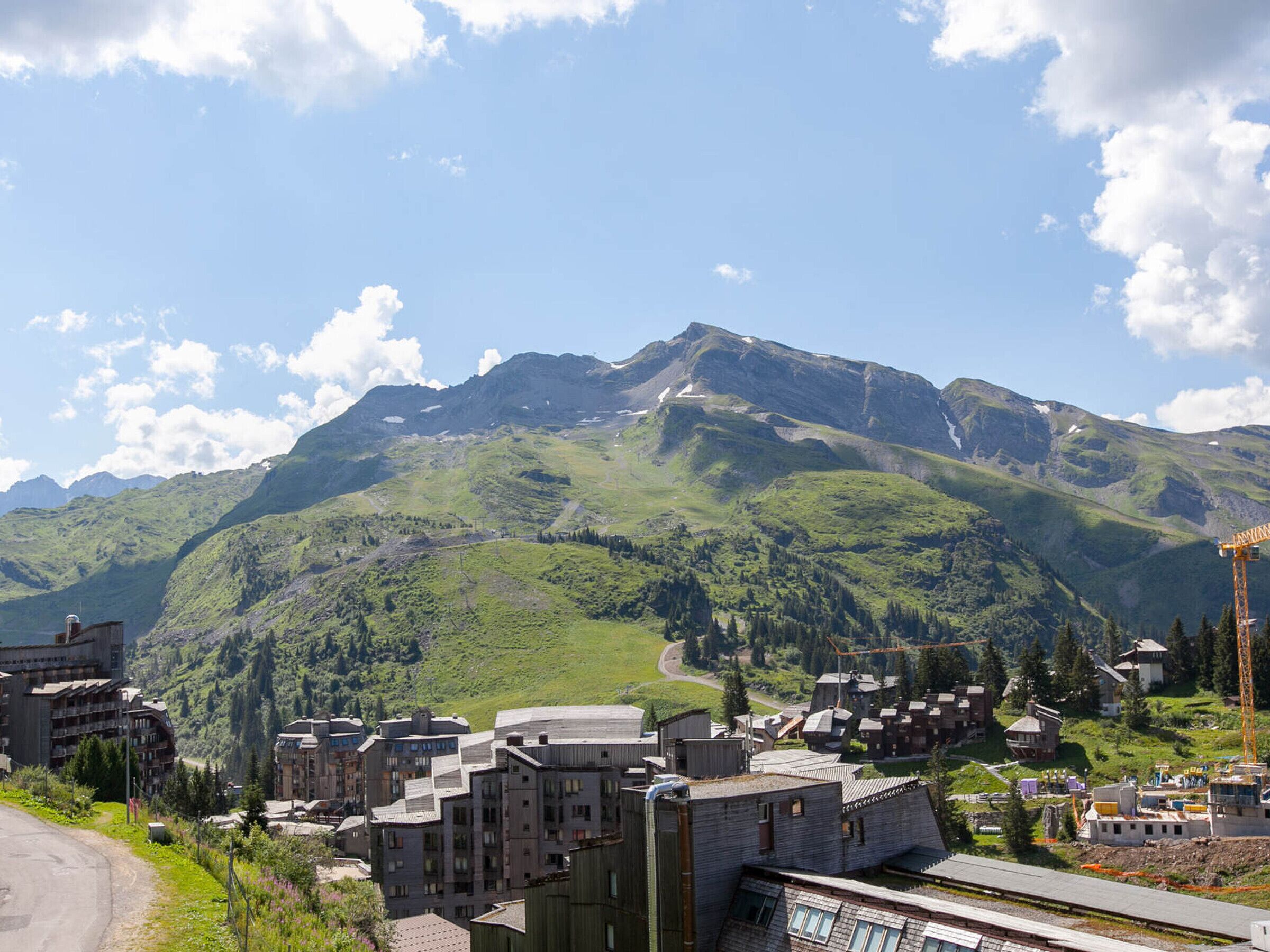 Une ville de montagne avec des bâtiments, une route et une montagne en arrière-plan.