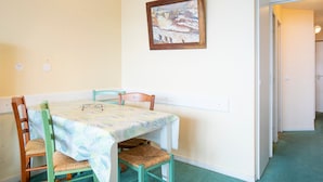 Un comedor con una mesa, sillas, una lámpara de araña y un cuadro en la pared.