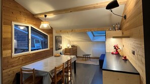 Ein gemütliches Blockhaus-Interieur mit Essbereich, Küche und Schlafempse.