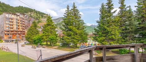 A wooden fence overlooking a town with buildings and trees.