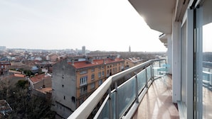 A balcony with a view of a cityscape, including buildings and a tower.