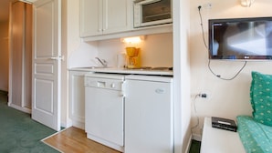 A compact kitchenette with a microwave, coffee maker, and a small refrigerator.