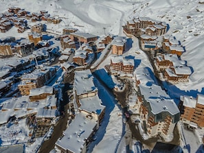 A snow-covered town with multiple buildings, including hotels and apartments, arranged around a central road.