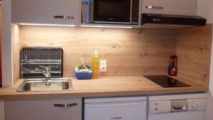 A compact kitchen with a Bosch dishwasher, a microwave, and a sink. - Studio for 4, Prime Ski Location, Balcony with Views, Wi-Fi, Pet-Friendly, Garage (Les Gets)