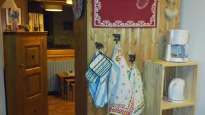 A kitchen with wooden cabinets, a coffee machine, and hanging kitchen towels. - Cozy family apartment in Les Gets with Wi-Fi, garage, 2 bedrooms (Les Gets)
