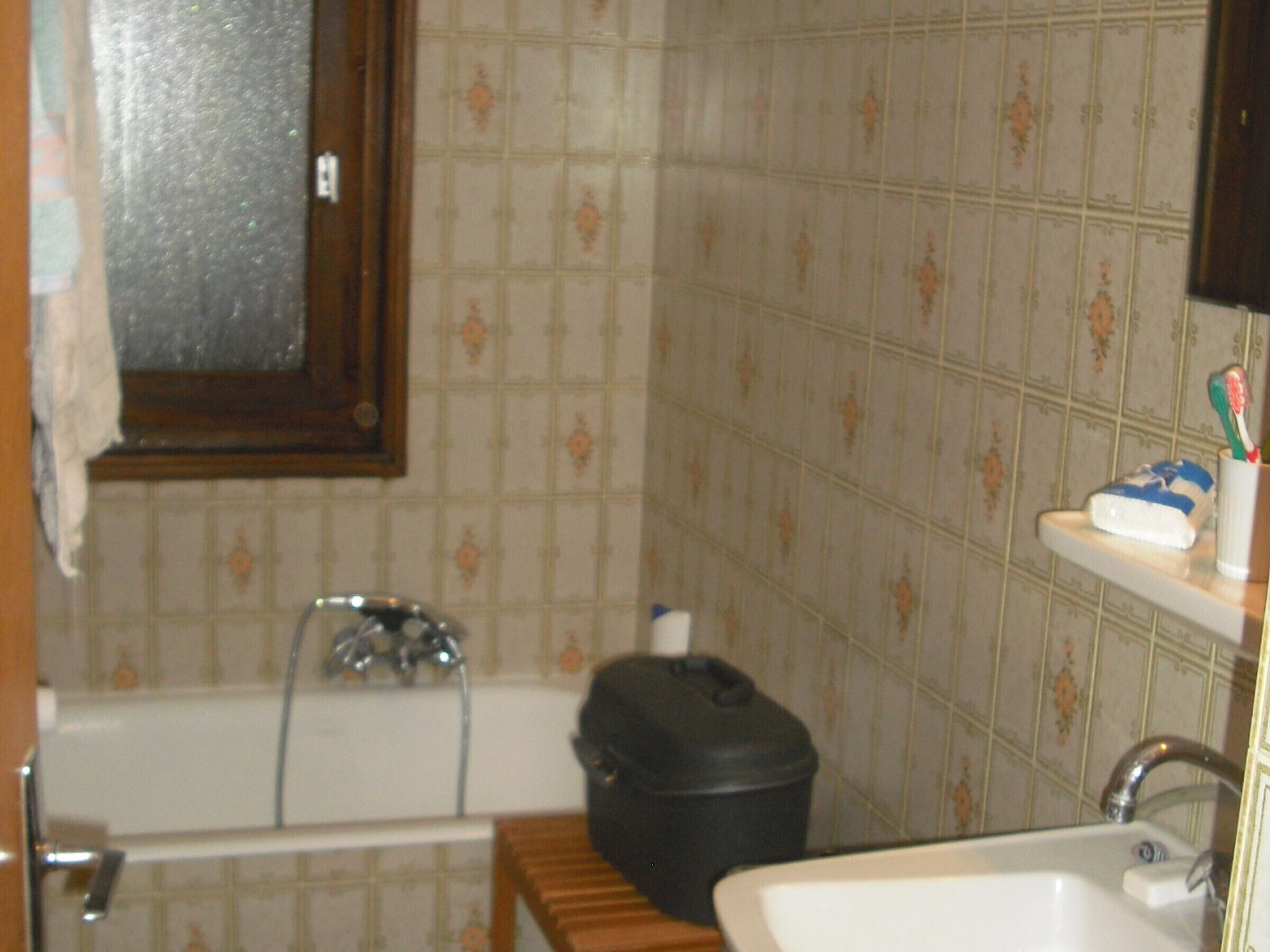 Un baño con bañera, lavabo, inodoro y un cubo de basura.