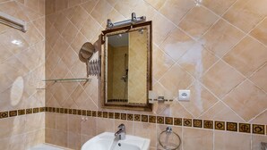 A bathroom with a bathtub, a sink, a mirror, and a shower. - Family Chalet for 8 in Courchevel Le Praz with Wifi (Courchevel)