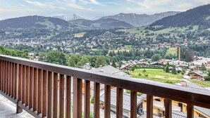 A balcony with a view of a town and mountains.