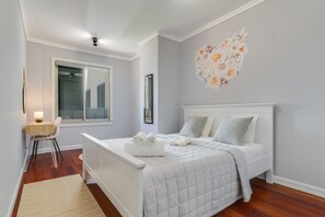 A bedroom with a white bed, a desk, and a chair. - Apartment Falesia Paradise (Funchal)