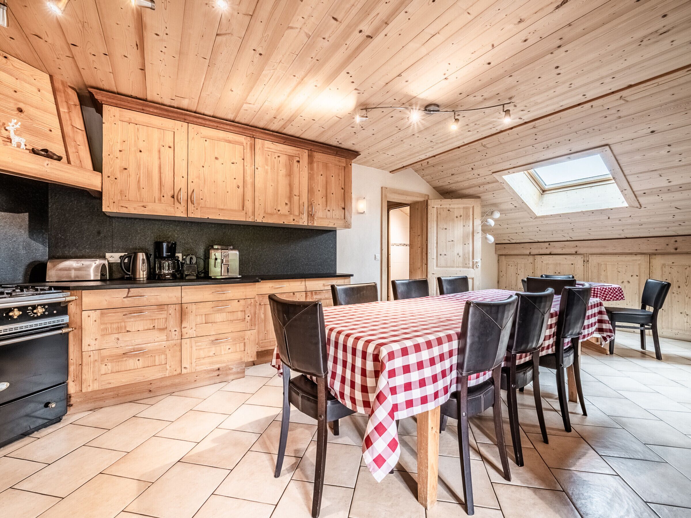 A wooden interior with a kitchen, dining area, and skylight.