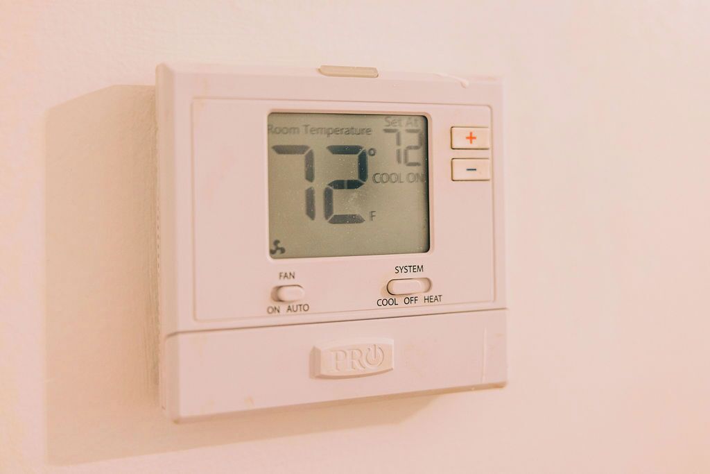 Een thermostaat met een digitaal beeldscherm waarop de kamertemperatuur wordt weergegeven.