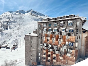 A multi-story building with a ski lift in the background.