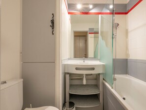 A compact bathroom with a toilet, sink, and shower.
