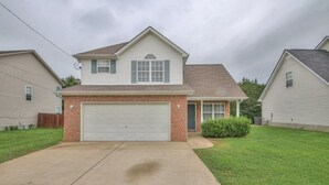 A two-story house with a garage, a front yard, and a brick facade. - Modern 3/2.5 near everything! Smryna- Off I-24! (Smyrna)