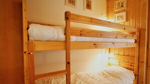 A bunk bed with a wooden frame and white bedding. - Renovated studio for 4 with fireplace in Avoriaz (Avoriaz)