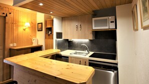 A modern kitchen with wooden cabinets, a stainless steel sink, and a microwave. - Renovated studio for 4 with fireplace in Avoriaz (Avoriaz)