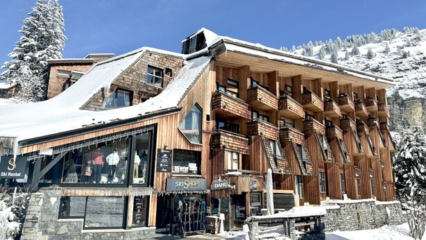 A wooden building with multiple balconies and large windows, surrounded by snow-covered trees and a clear blue sky. - Renovated studio for 4 with fireplace in Avoriaz (Avoriaz)