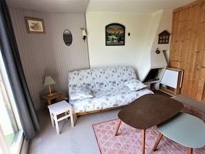 A cozy room with a patterned sofa, a small table, a lamp, and a fireplace. - Renovated studio for 4 with fireplace in Avoriaz (Avoriaz)