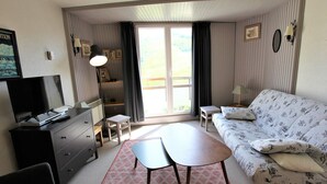 A compact hotel room with a bed, a sofa, a TV, a desk, and a small table. - Renovated studio for 4 with fireplace in Avoriaz (Avoriaz)