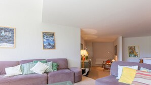 A living room with two sofas, a glass coffee table, and a lamp.
