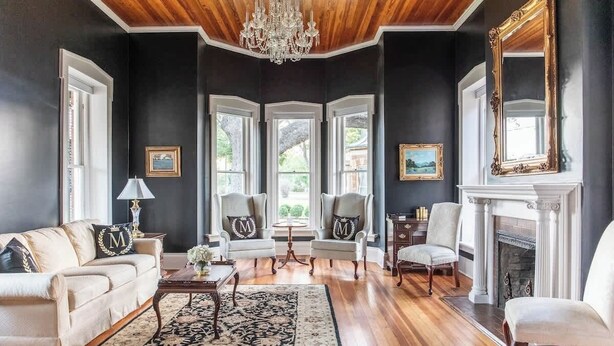 A formal living room with a fireplace, elegant furniture, and a chandelier. - The Mildred Haus (Mason)