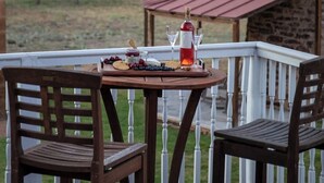A wooden deck with a table set for a meal, surrounded by white railings. - The Mildred Haus (Mason)