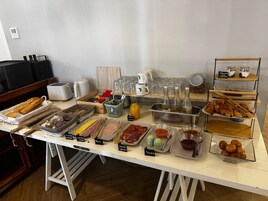 A buffet table with various food items and condiments.