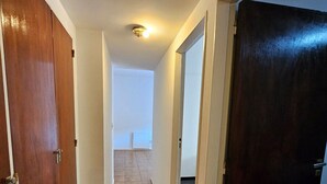 A hallway with wooden doors, a tiled floor, and a ceiling light. - Exquisito 3 ambientes Congreso (Buenos Aires)