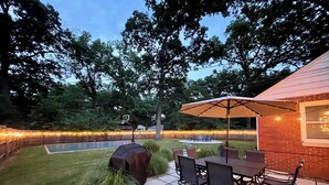 A backyard with a patio table and chairs, a barbecue grill, and a basketball hoop. - Backyard Vibes-Walk to ND-Dogs Welcome-BBall Hoop-Fire Pit-Sleeps 12-2024 Reno (South Bend)