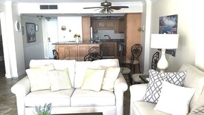A living room with two sofas, a coffee table, and a dining table with chairs. There is a kitchen area visible in the background. - Oceanfront Beautiful Views 2 Bd and 2 Baths Family-Friendly Lovely Furnishings (Myrtle Beach)