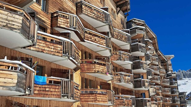 A multi-story wooden building with balconies, likely a hotel or resort.