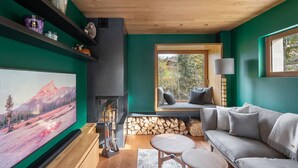 Ein gemütliches Wohnzimmer mit Kamin, großem Fernseher und einer bequemen Sitzecke.