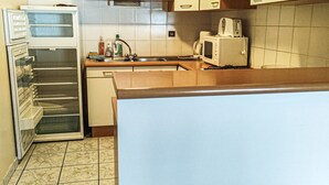 A kitchen with a refrigerator, microwave, sink, and cabinets. - Large apartment for 8, pets allowed, parking, near the slopes (Les Gets)
