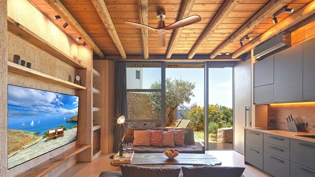 Una sala moderna con televisor, sofá y comedor.