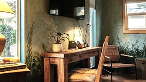 A room with a wooden desk, a chair, a television mounted on the wall, and a window with blinds. - Professionally designed, centrally located to wineries and red rocks, premium bedding for a positive reset. Dogs Welcome. (Cornville)