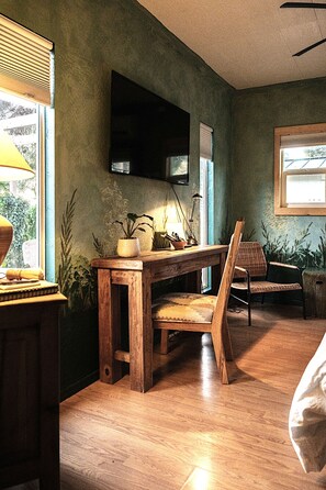 A room with a wooden desk, a chair, a television mounted on the wall, and a window with blinds. - Professionally designed, centrally located to wineries and red rocks, premium bedding for a positive reset. Dogs Welcome. (Cornville)